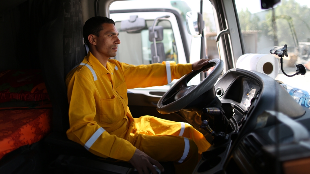 Roshan Bhattrai has been driving for Qatari Al Fadal Transport and Trading Company for years. He says that 95 percent of the transport fleet has been modified and retrained for new transport routes after the blockade was imposed [Showkat Shafi/Al Jazeera]