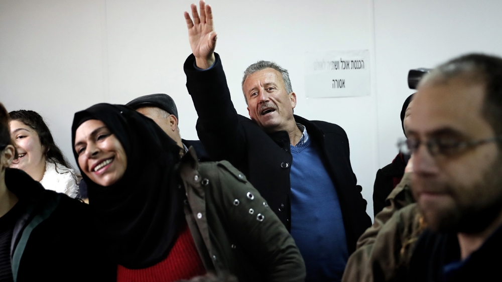 Ahed Tamimi's father, Bassem, waves as she arrives for her trial in West Bank on Tuesday [AFP]