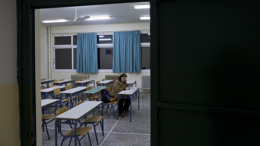 Ioanna takes an exam for her night school course, which is held at the same school her daughter attends [Yannis Kolesidis/Al Jazeera]