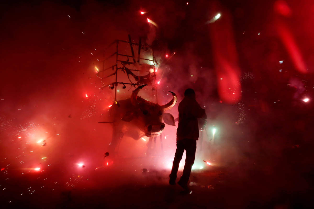 A man enjoys the fireworks exploding from a traditional bull figure known as "El Torito" during the annual San Juan de Dios celebrations in Tultepec, on the outskirts of Mexico City, Mexico March 8, 2
