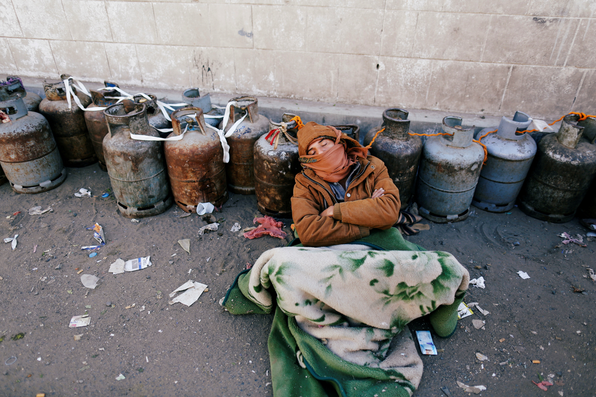 A man sleeps next to a queue of cooking gas cylinders outside a gas filling station amid a scarcity in cooking gas supplies in Sanaa, Yemen March 4, 2018 . REUTERS/Khaled Abdullah TPX IMAGES OF THE DA