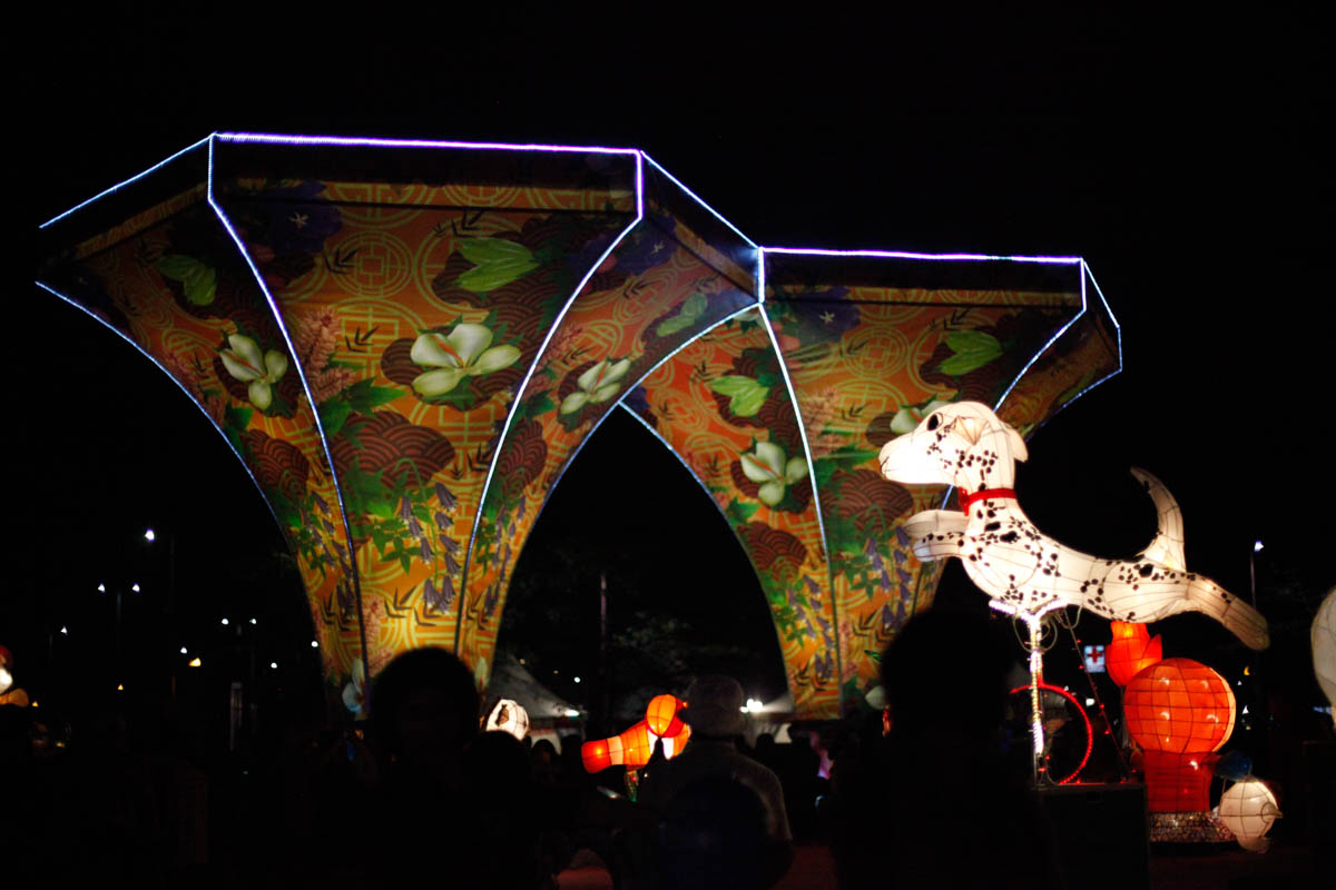 A Dalmatian dog styled lantern lit by LED lights jumps up among many other dog lanterns in front of the Reception Gate of 2018 Taiwan Lantern Festival. It is made by elementary school kids in Chiayi C