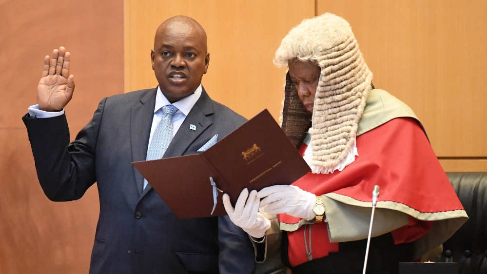 Masisi, left, takes the oath with the Chief Justice Maruping Dibotelo [Monirul Bhuiyan/AFP]