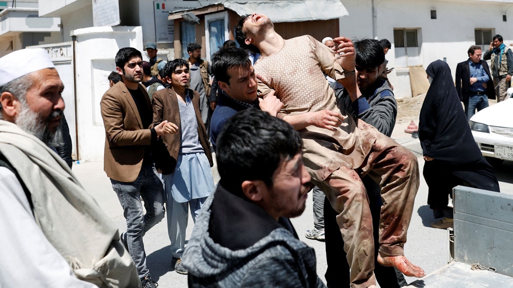Relatives of victims carry an injured man outside a hospital in Kabul [Mohammad Ismail/Reuters]