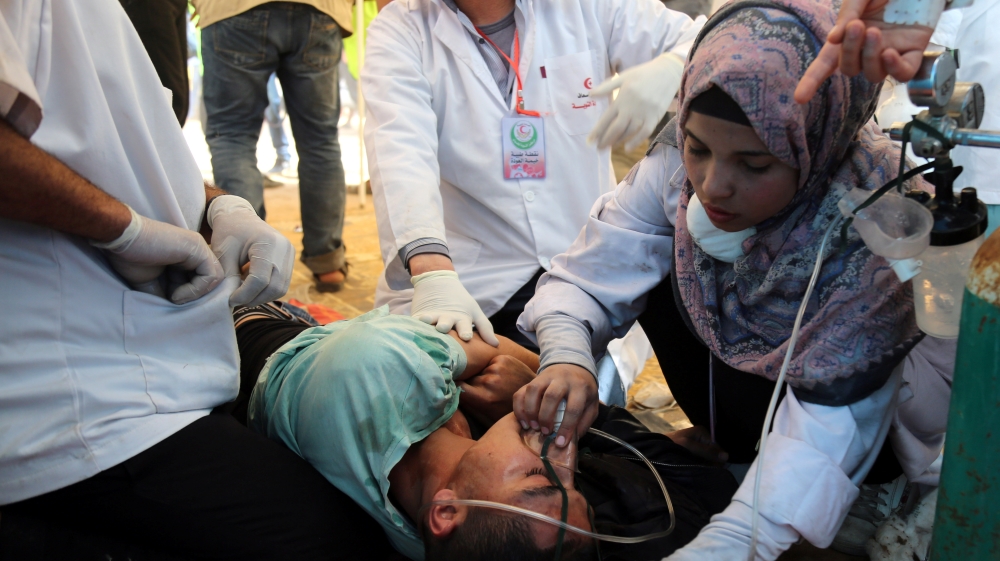 Shorouq Abu Musameh, who volunteers with other paramedics, tends to a Palestinian who inhaled tear gas fired by Israeli troops during a protest, at the Israel-Gaza border, in the southern Gaza Strip