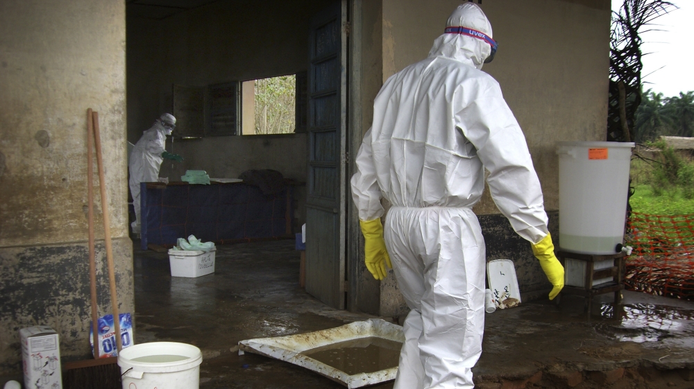 Medical workers in protective clothings work in the Ebola isolation zone at the village of Kampungu, DRC [Frederic Patign