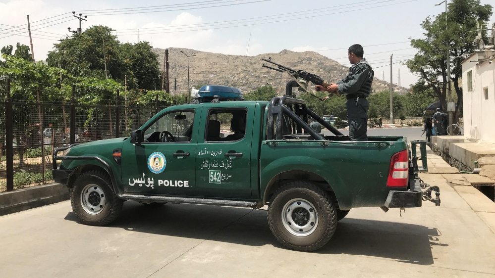 Afghan police officer keeps watch at the site of a blast in Kabul