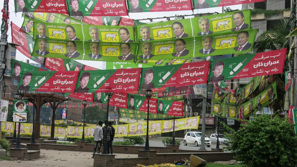 Elections banners for the PML-N and PTI parties fly across Lahore, as the two leading parties in the elections face off for control of the country [Asad Hashim/Al Jazeera]