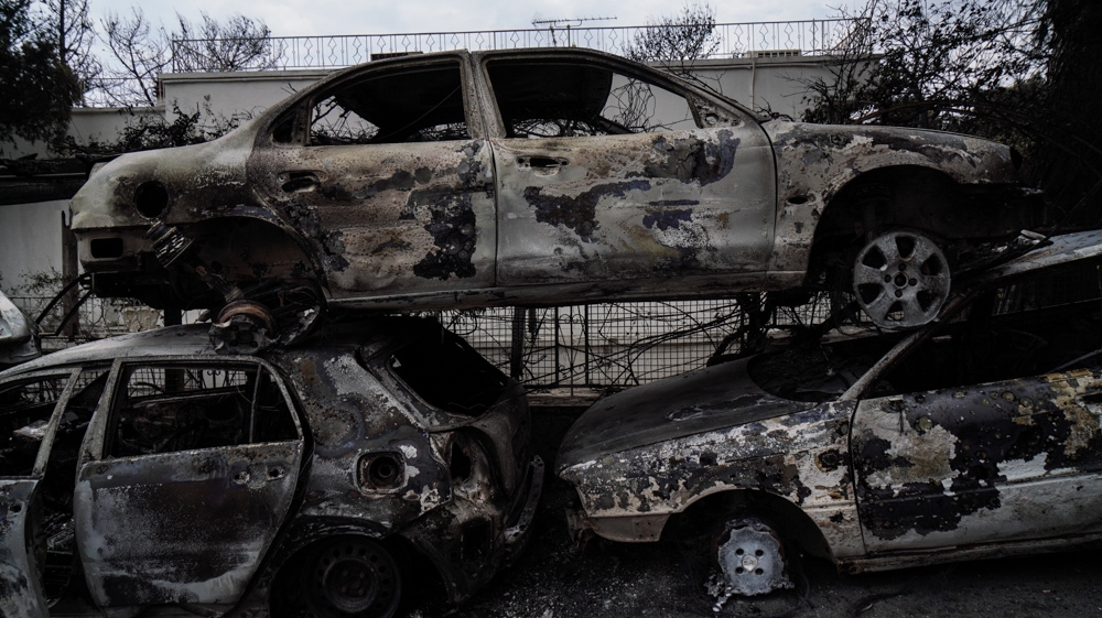 Rescue workers used forklifts to stack charred cars so emergency vehicles could get through the streets [Nick Paleologos/SOOC] 
