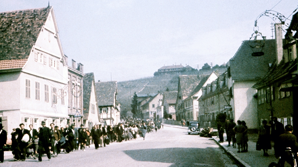 Roma under police surveillance march down Konigstrasse in Asperg, Germany, on May 22, 1940. They will be locked up in prison prior to deportation to camps in Poland [File: Galerie Bilderwelt/Getty Images]