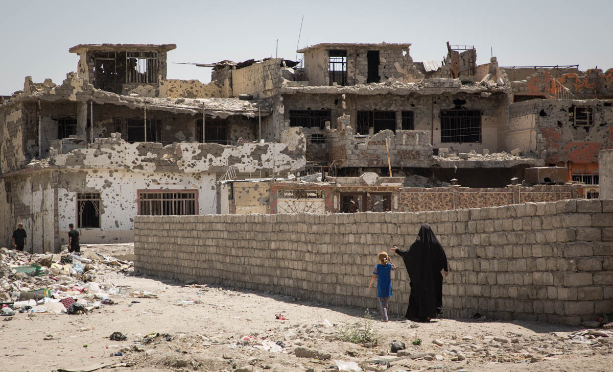 Picture 1 A mother and her daughter walk back to their neighbourhood in West Mosul. Destruction this area is everywhere. Rubbles and explosive remnants litter the streets and crumbled houses. Photo: