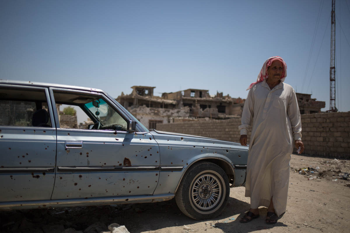 Picture 3 A car damaged by shrapnel and its owner. A shell hit Akram’s house during retaking operations one year ago. His car still bears the marks of the explosion. His car is miraculously still roll