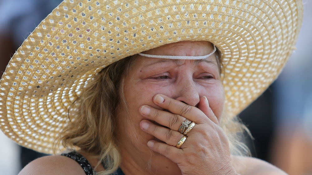 A woman reacts while visiting the scene of Sunday's shooting in Toronto [Chris Helgren/Reuters]