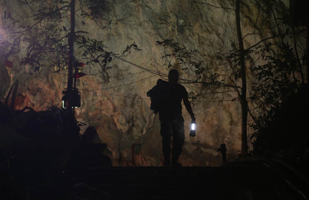 A rescuer makes his way down at the entrance to a cave complex where 12 boys and their soccer coach went missing, in Mae Sai, Chiang Rai province, in northern Thailand, Wednesday, July 4, 2018. Rescue