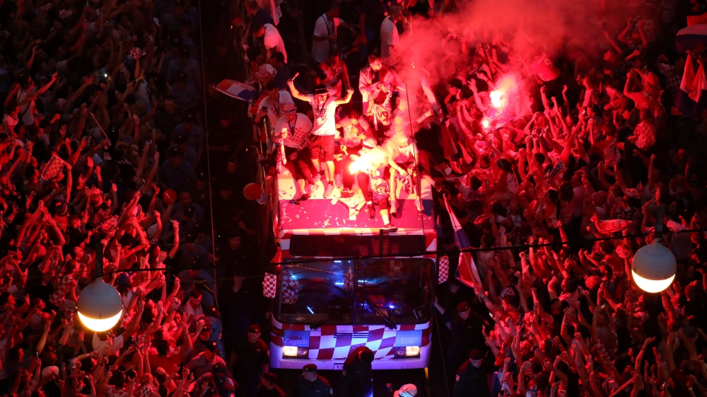 Flares, cheering and flags welcomed the team bus into the city centre [Marko Djurica/Reuters]
