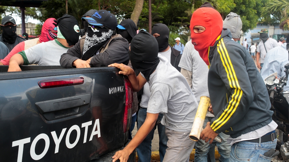 Government supporters stand in front of a church in Diriamba [Oswaldo Rivas/Reuters]