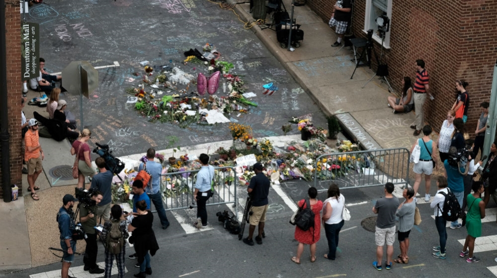 Mourners and passersby surround an impromptu memorial commemorating the victims of the car attack on a group of counterprotesters during the 2017 