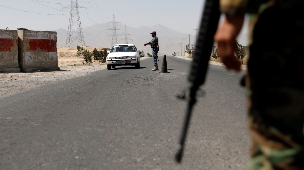 An Afghan policeman keeps watch at a checkpoint on the Ghazni highway, in Maidan Shar, the capital of Wardak province, Afghanistan