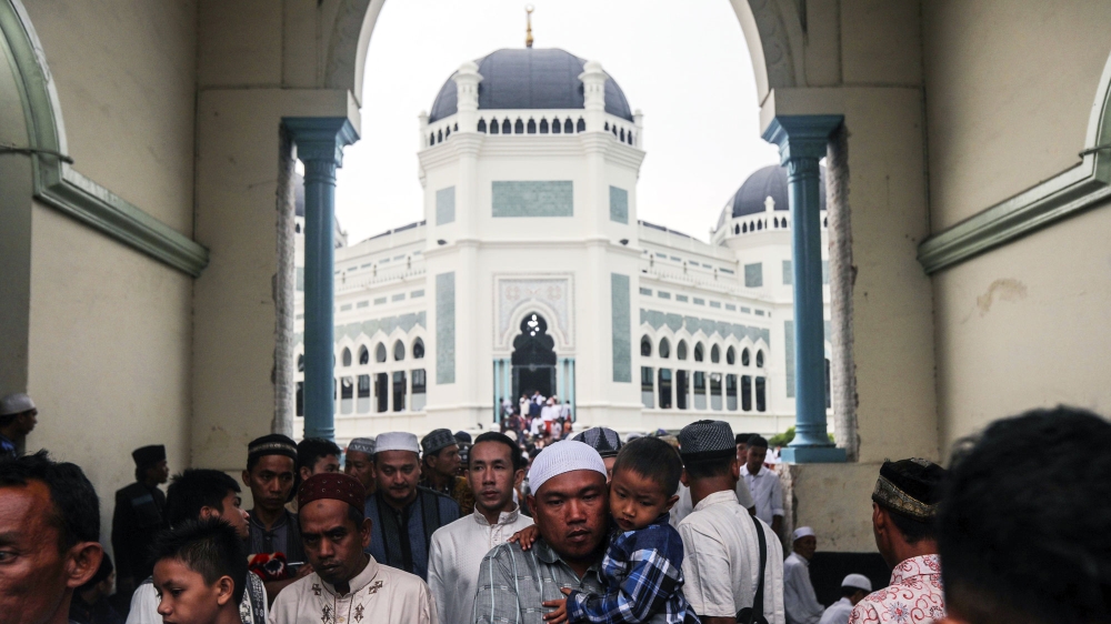 Indonesian Muslims walk out of a mosque after attending the Eid al-Adha prayers in Medan, North Sumatra, Indonesia