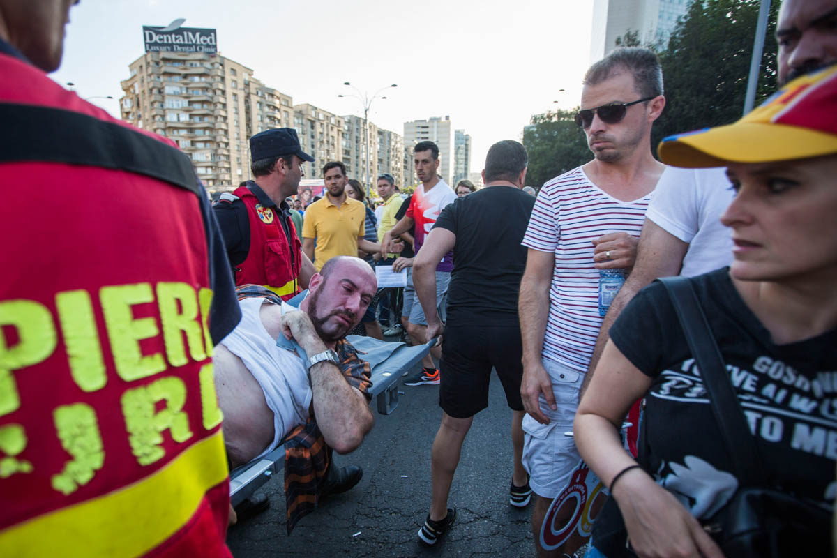 A man was transported by paramedics to an ambulance after suffering from tear gas exposure. More than 450 people including 30 riot police were treated for injuries during the clashes. [Alexandra Radu/