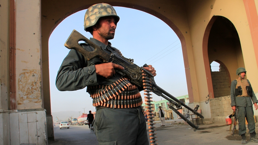 An Afghan policeman keeps watch at a check point in Ghazni city, Afghanistan