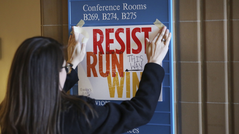 n this Saturday, Dec. 9, 2017 photo, Lianna Stroster posts a sign directing to a women''s candidate training workshop at El Centro College in Dallas.