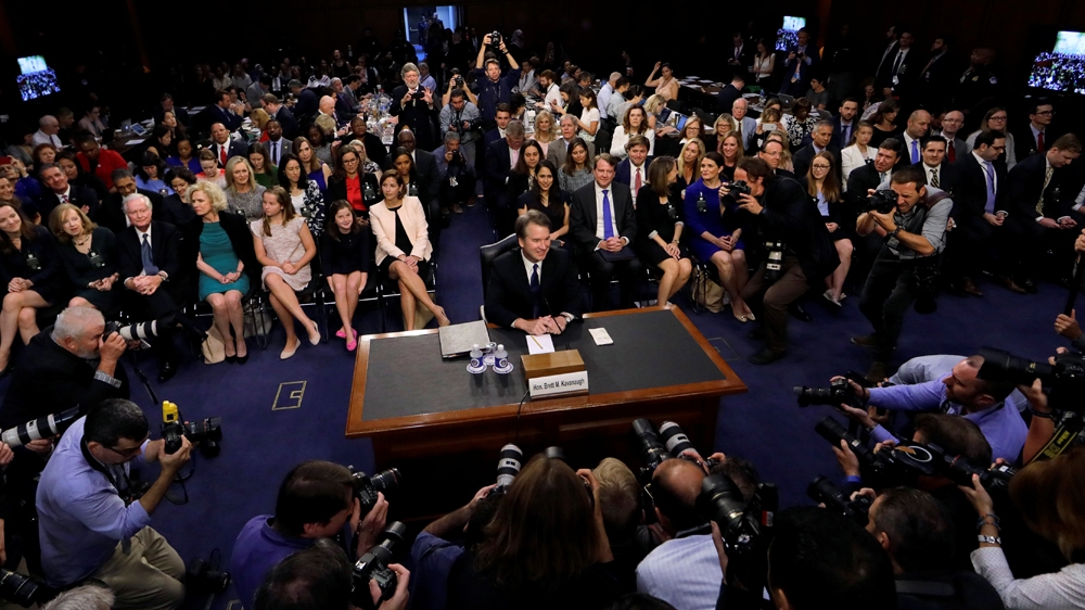 Brett Kavanaugh is surrounded by photographers as he takes his seat for his Senate Judiciary Committee confirmation hearing on September 4, 2018 [Jim Bourg/Reuters]