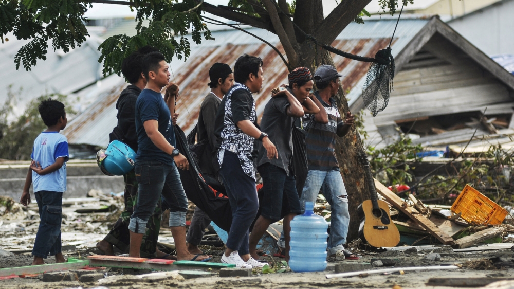 Residents carry the body of a victim following an earthquake and tsunami in Palu, Central Sulawesi [Antara Foto/Zainuddin Mn/Reuters]