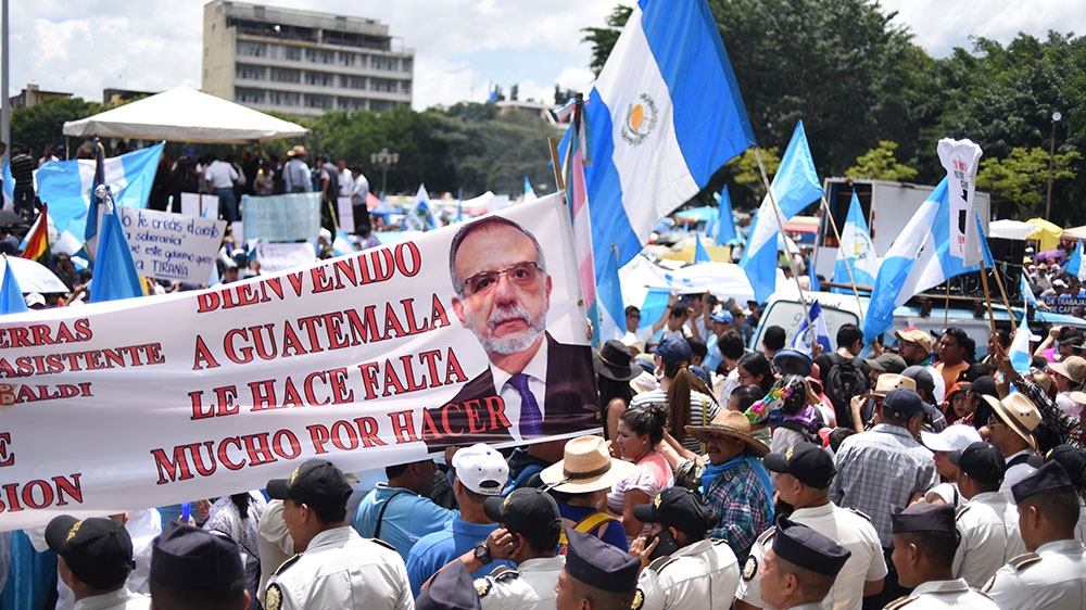 People hold a banner depicting CICIG commissioner Ivan Velasquez during a march called by university students to demand the resignation of President Morales in Guatemala City [Johan Ordonez/AFP]
