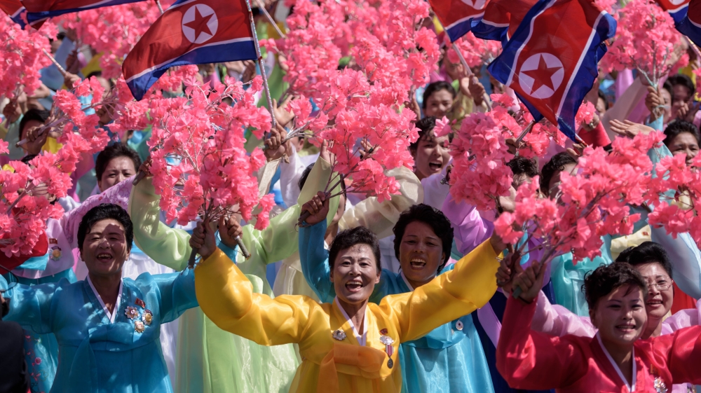 Thousands of civilians walked through the square waving bouquets [Ed Jones/AFP]