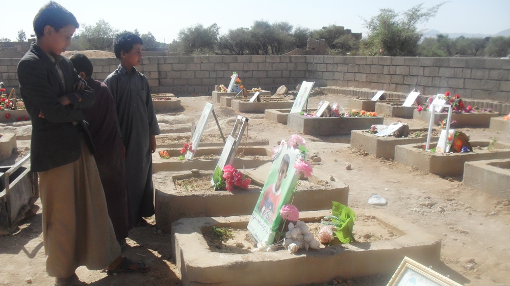 Hassan Hanash and his two brothers, Ahmed Ali and Yahya, pray for their friends who were killed in a Saudi air raid on a school bus in August [Naseh Shaker/Al Jazeera]