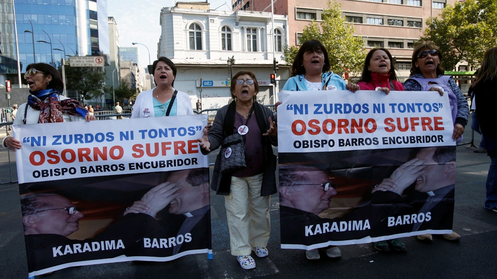 People hold banners reading 'Neither lefties nor fools, Osorno suffers, Bishop Barros, accessory after the fact,' during a protest, as Pope Francis visits Santiago, Chile [File: Carlos Vera/Reuters]