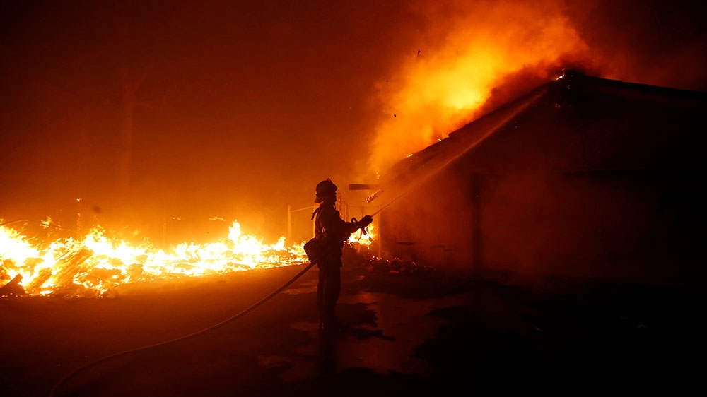A firefighter battles the Woolsey Fire in Malibu, California [Eric Thayer/Reuters]