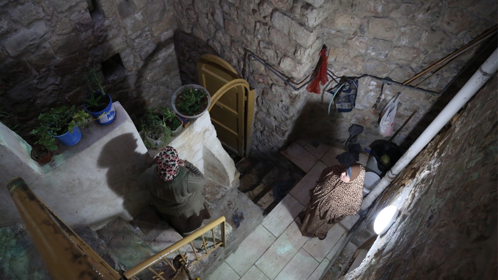 Basma Ewaiwe [right] is proud that her plants can grow despite the lack of sunlight [Mersiha Gadzo/Al Jazeera]