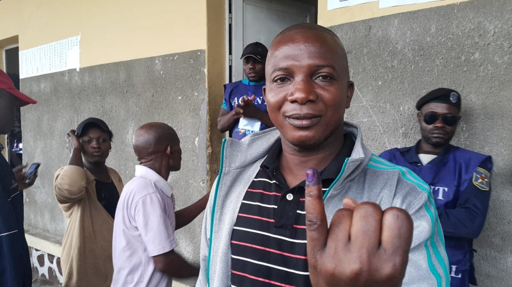
A man displays ink on his hand after casting his vote at a polling station in Kinshasa [Hamza Mohamed/Al Jazeera]
