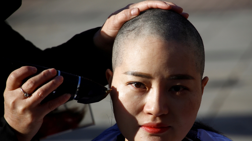 Li Wenzu has shaved her head in protest to her husband's detention [Thomas Peter/Reuters]