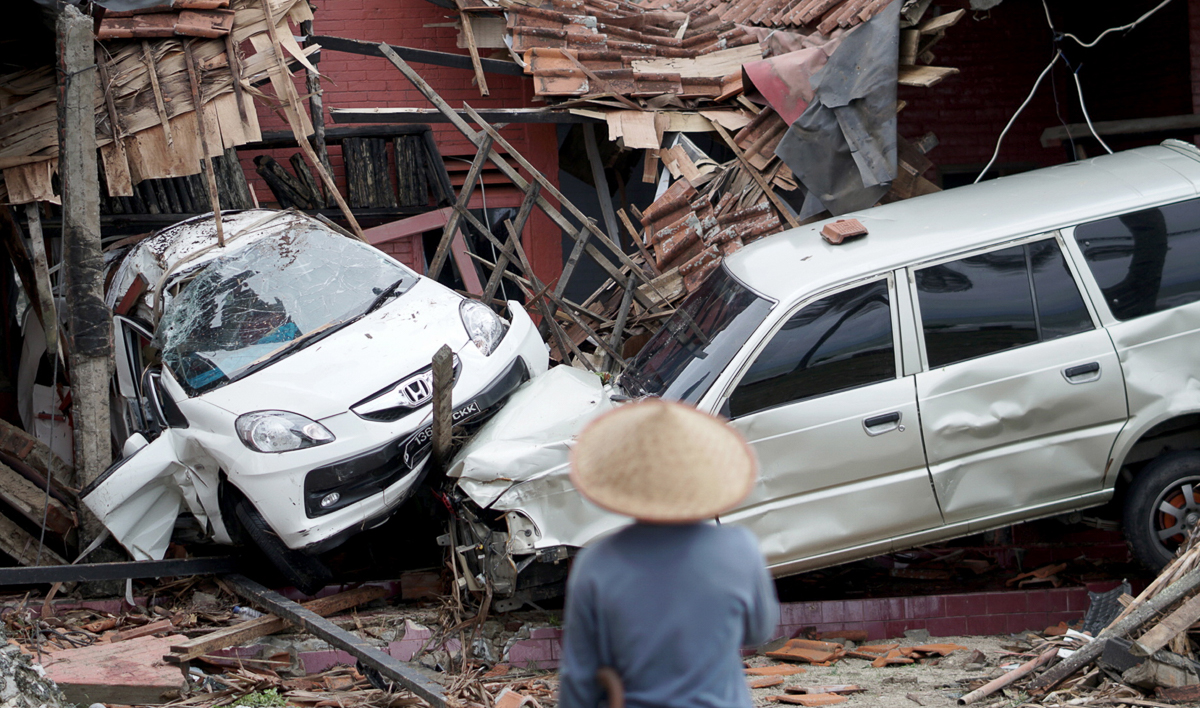 An Indonesian man looks at ruined vehicles after a tsunami hit Sunda Strait in Anyer, Banten, Indonesia, 23 December 2018. According to the Indonesian National Board for Disaster Management (BNPB), at
