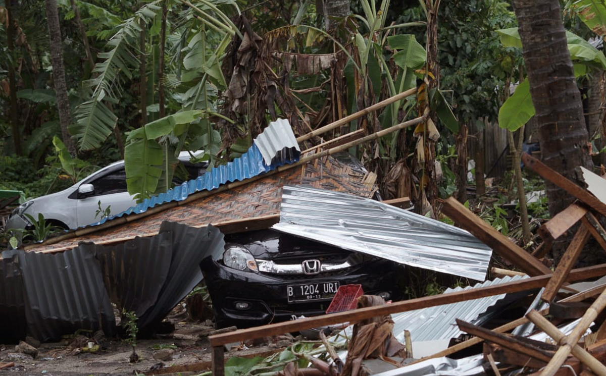 Cars are covered by debris at an area ravaged by a tsunami, in Carita, Indonesia, Sunday, Dec. 23, 2018. The tsunami apparently caused by the eruption of an island volcano killed a number of people ar