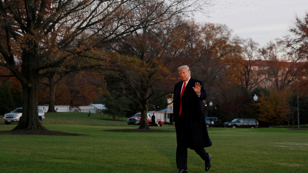 U.S. President Donald Trump walks across the South Lawn after returning to the White House in Washington