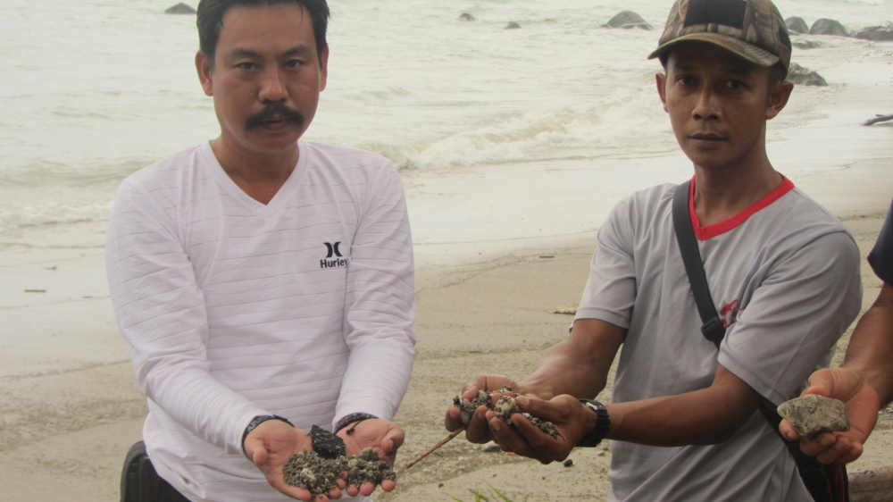 Rajabasa residents holding solidified lava which washed up from the volcano [Teguh Harahap/Al Jazeera] 