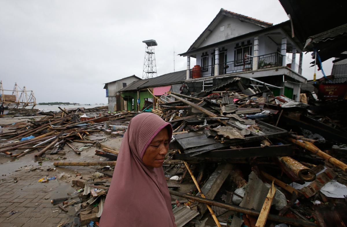 A tsunami survivor walks at a tsunami-ravaged village in Sumur, Indonesia, Tuesday, Dec. 25, 2018. The Christmas holiday was somber with prayers for tsunami victims in the Indonesian region hit by wa