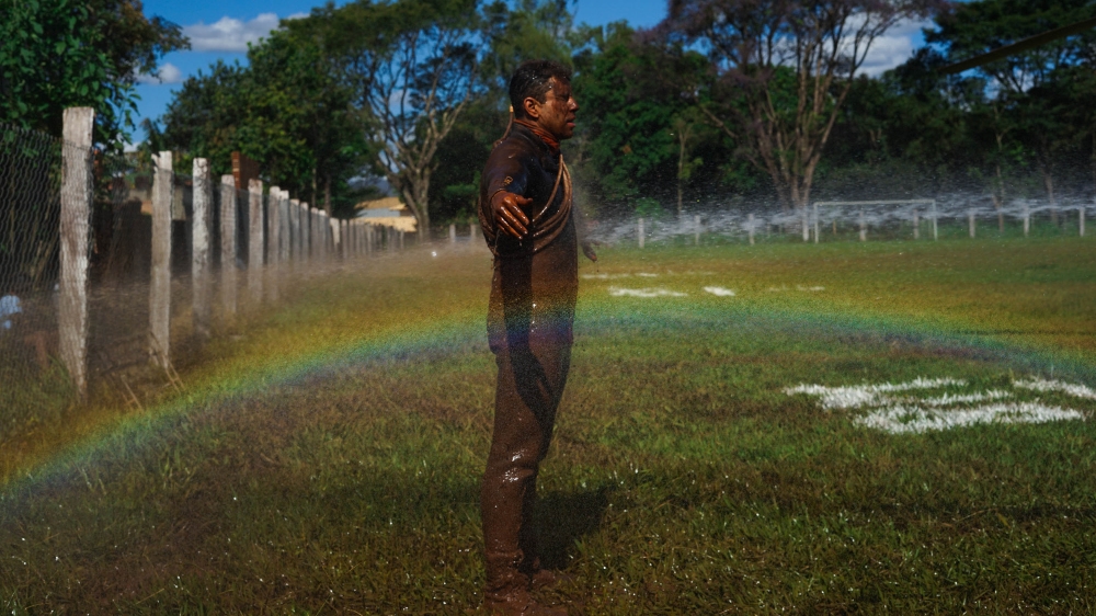 A rescue worker is rinsed off after searching through the mud for bodies of victims [Mia Alberti/Al Jazeera] 