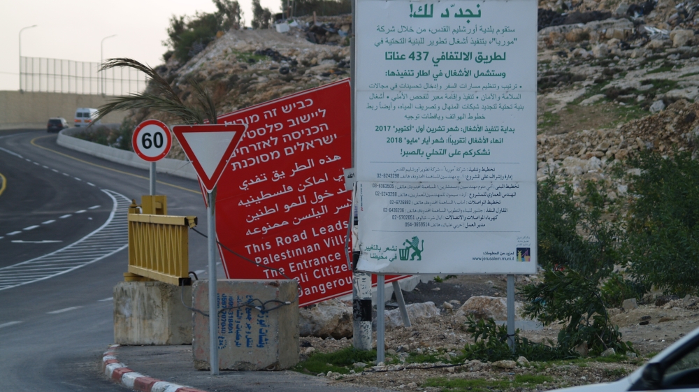 The road has red 'dangerous for Israelis to enter' signs that signal a Palestinian-only route [Megan Giovannetti/Al Jazeera]