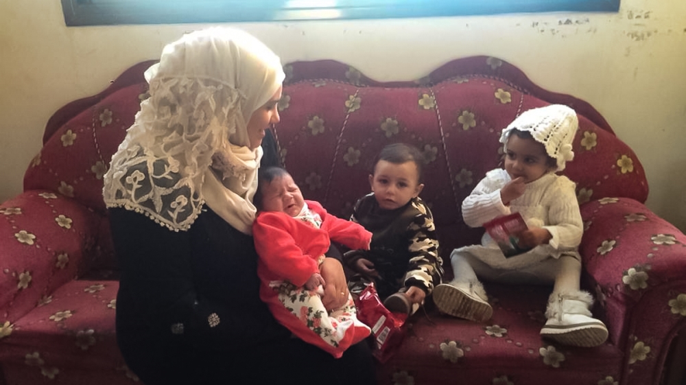 Zainab al-Samouni with her three children at her home in Gaza City [Maram Humaid/Al Jazeera] 