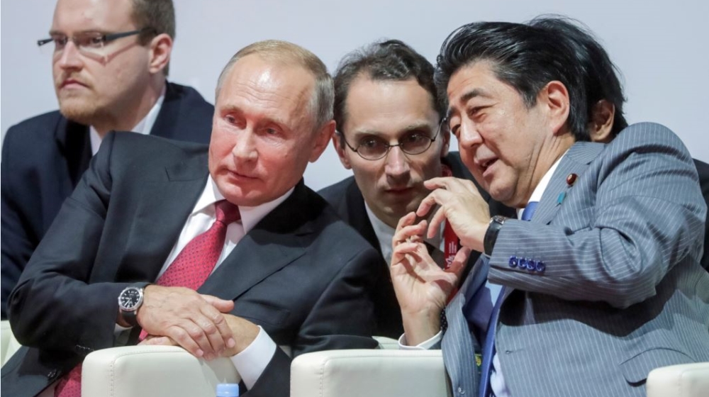 Russian President Vladimir Putin, left, listens to Japanese Prime Minister Shinzo Abe