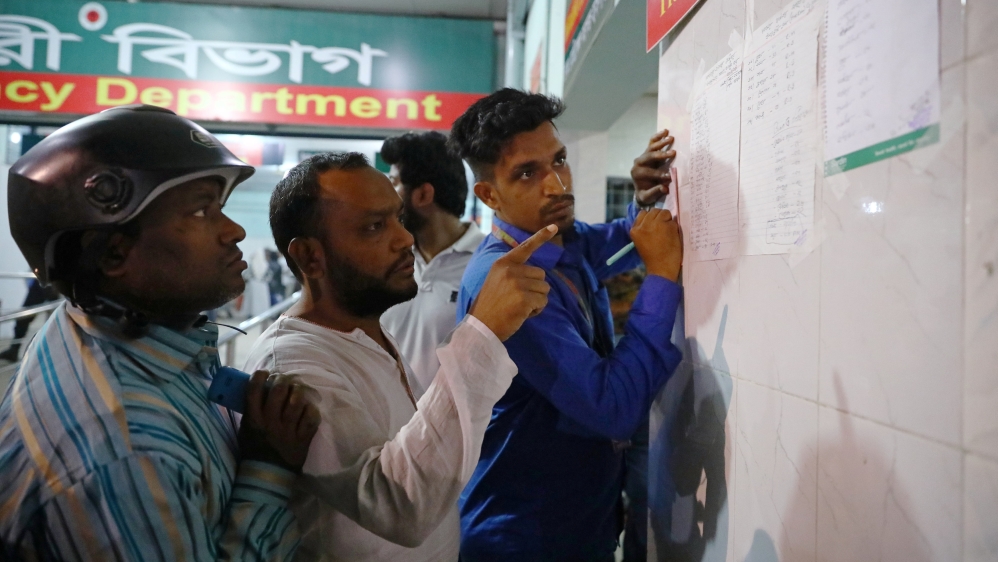 People look at a list with the names of those injured in the fire [Mohammad Ponir Hossain/Reuters]