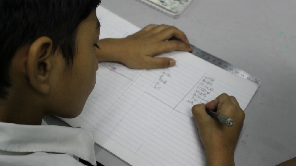 A boy learning the Burmese language at a school run by ethnic Chin refugees in Malaysia [Kate Mayberry/Al Jazeera]