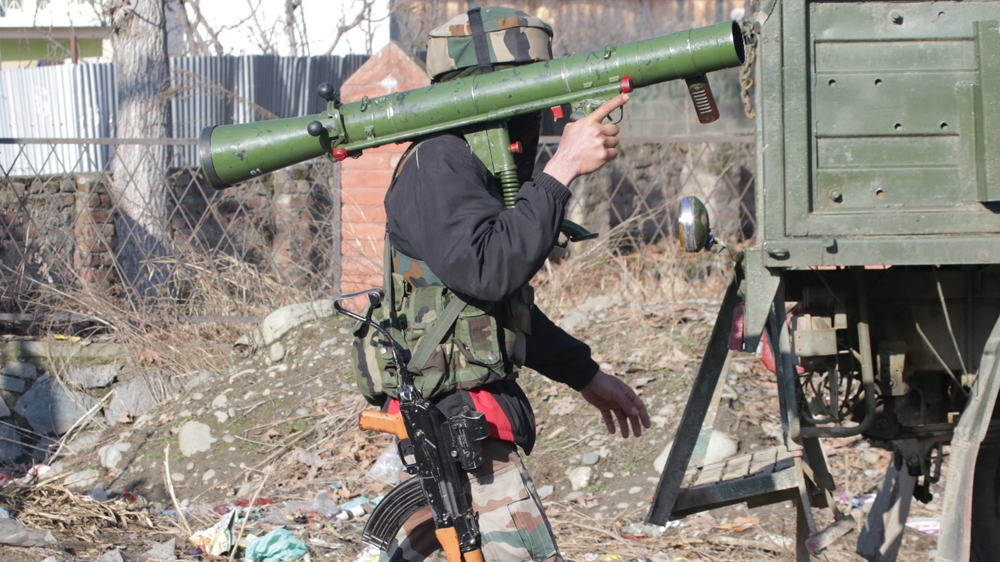 An Indian army soldier carries a rocket launcher near the site of the gun battle in Pinglan village [Younis Khaliq/Reuters]