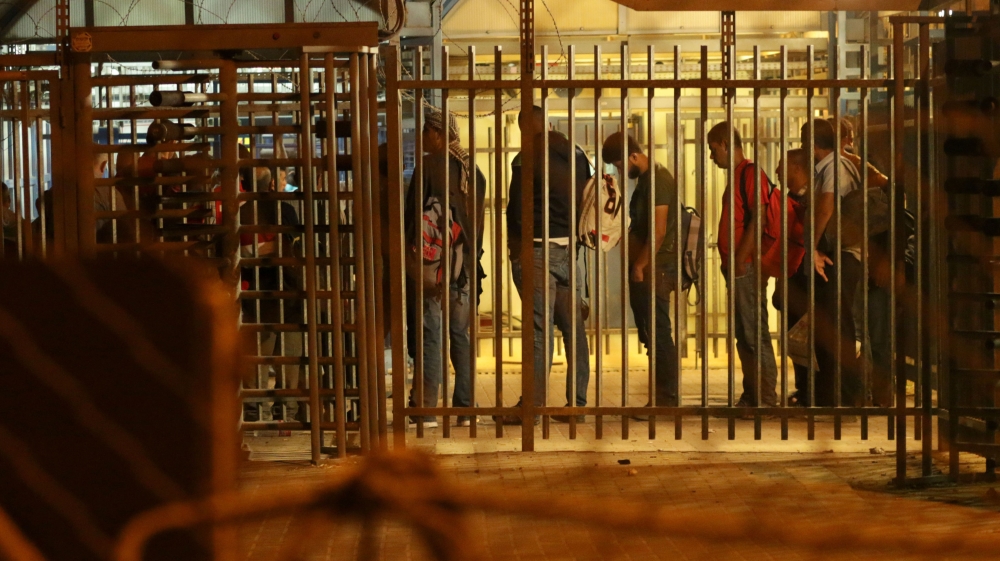 Thousands of Palestinian workers from the West Bank queue early morning at the Israeli checkpoint of Tarqumiya, near Hebron, in order to reach their workplaces in Israeli and Arab-Palestinian cities beyond the Green Line on August 20, 2017. While Israeli-Jews travel freely across the Green Line, Palestinians are required to have an Israeli military-issued permit in order to cross [Ahmad Al-Bazz/Activestills/Al Jazeera]
