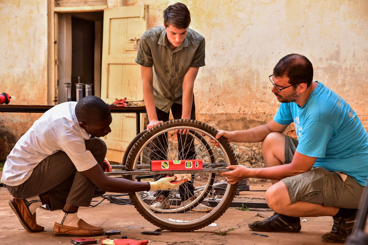 Nkuutu Brian Jeremiah a field officer (L), Franz Stiegel (volunteer) (M) and Georg Siegel Managing Director at FABIO putting finishing touches on the new ambulance carrier being constructed at their
